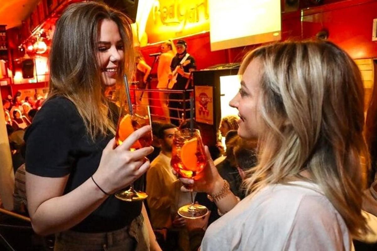 dve ženy stojace v bare držiace poháre na víno