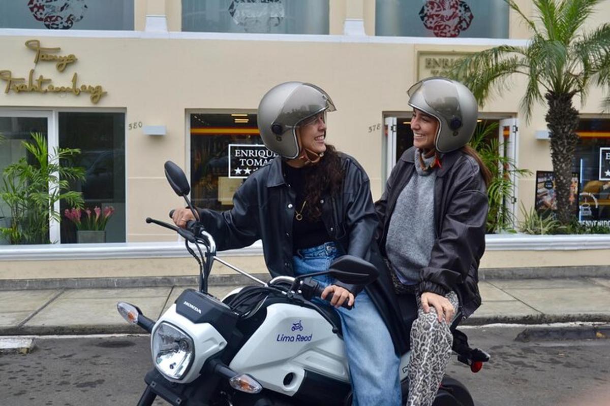 duas pessoas usando capacetes sentadas em uma scooter