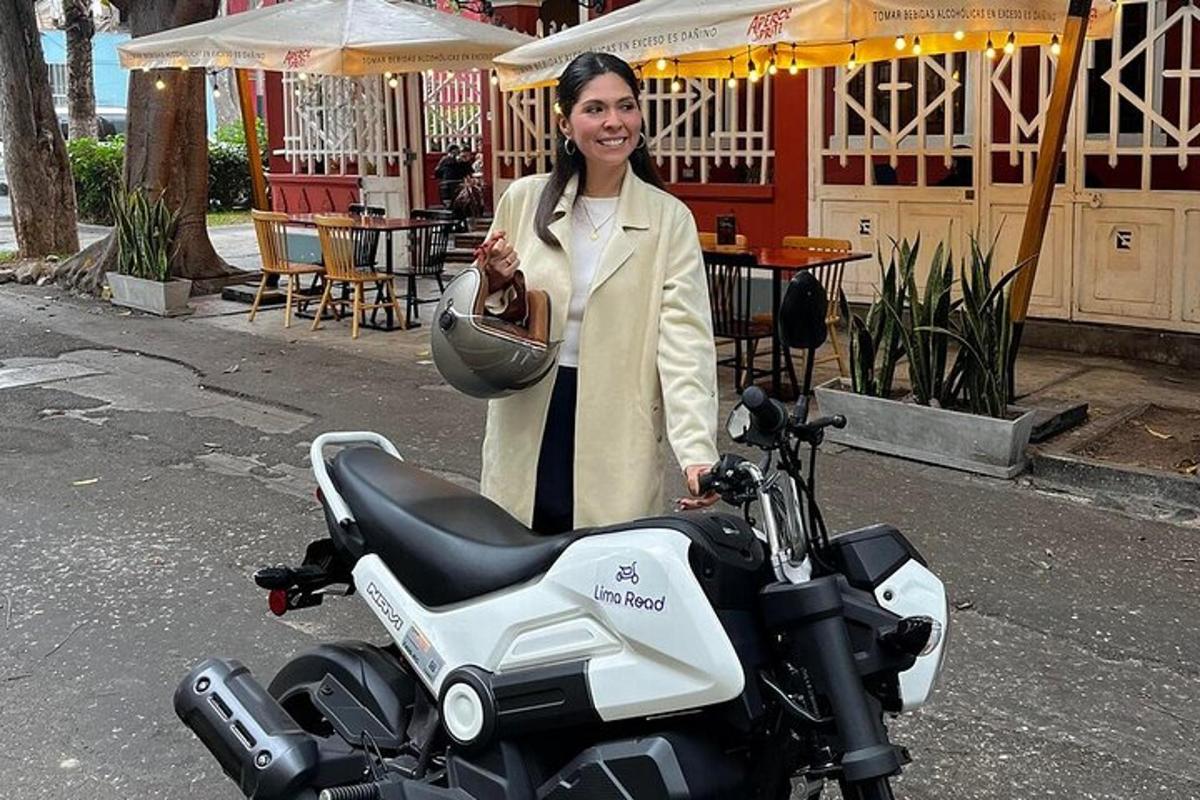 una donna è in piedi accanto a una motocicletta