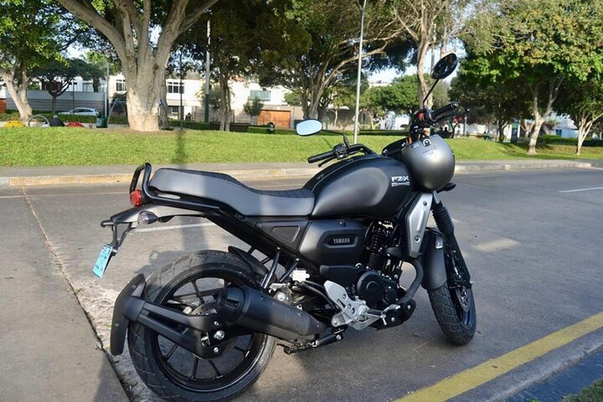 una motocicletta nera parcheggiata sul ciglio di una strada