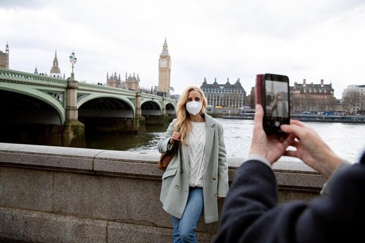 คนกำลังถ่ายรูปผู้หญิงสวมหน้ากาก