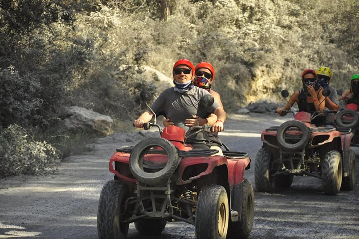 未舗装道路をATVで走る人々のグループ