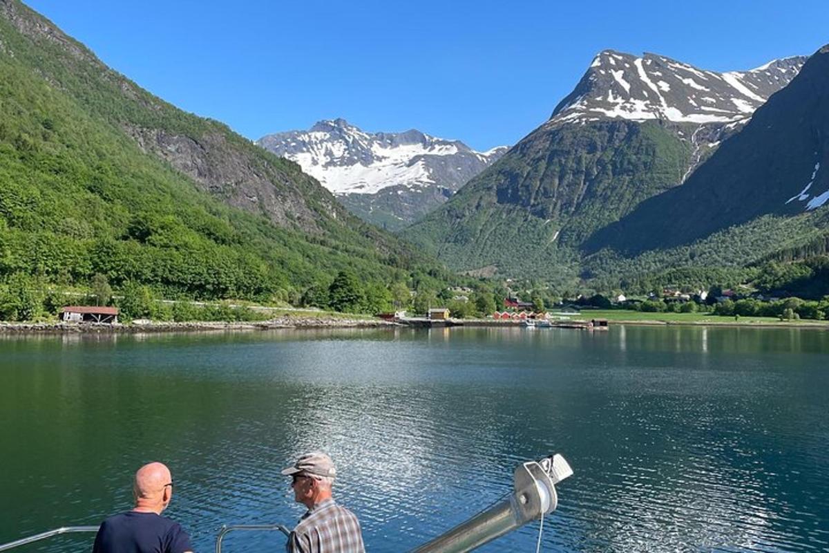 Tveir menn á báti á vatni með fjöllum