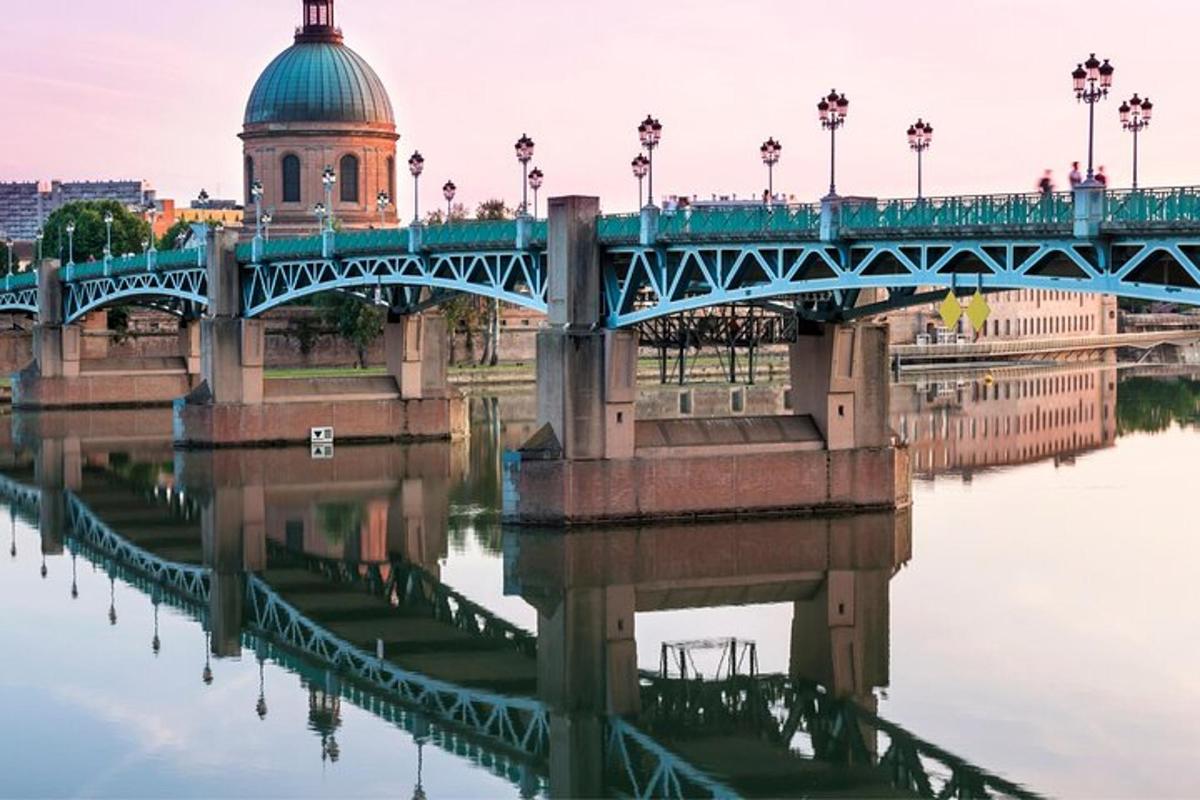 un pont sur une rivière avec un bâtiment en arrière-plan