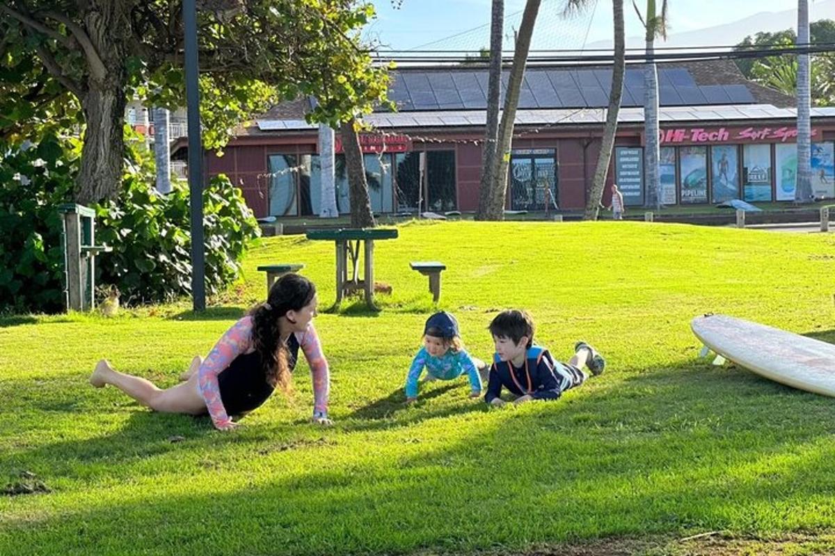 a woman and two children laying in the grass