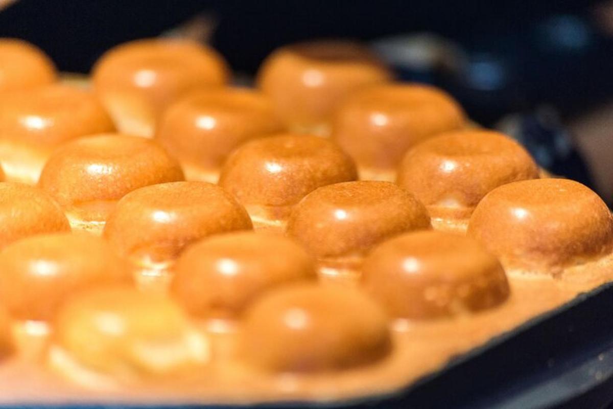 Una bandeja de donas cubiertas de chocolate sobre una mesa.
