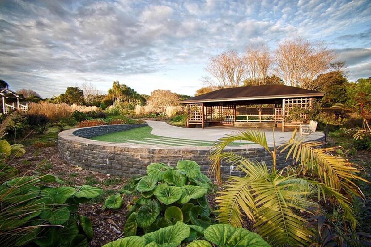 a garden with a building with a stone wall