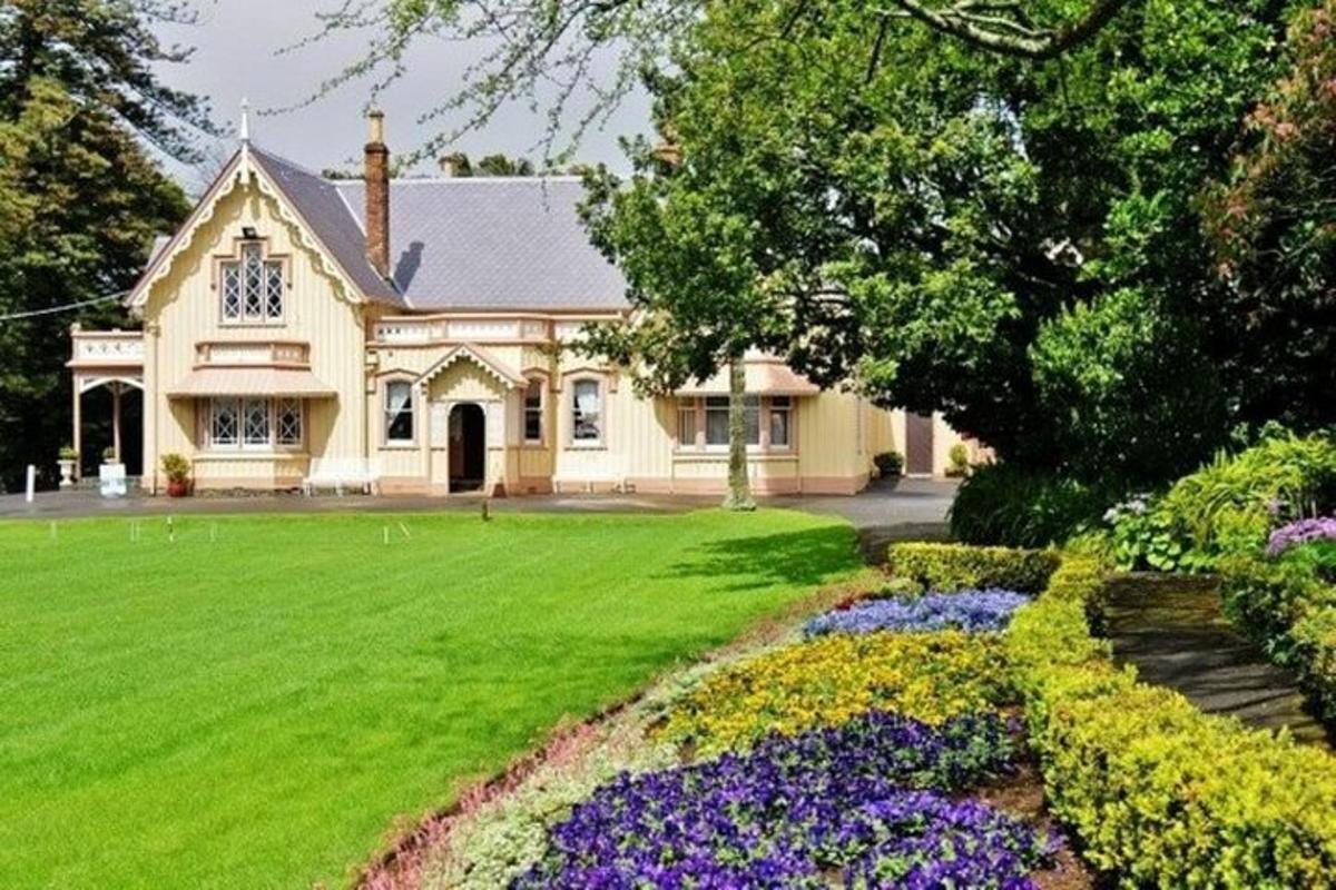 a house with a green lawn and purple flowers