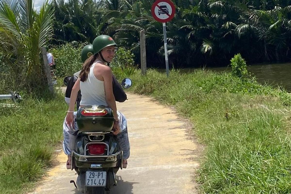Una mujer que conduce una motocicleta por un camino de tierra