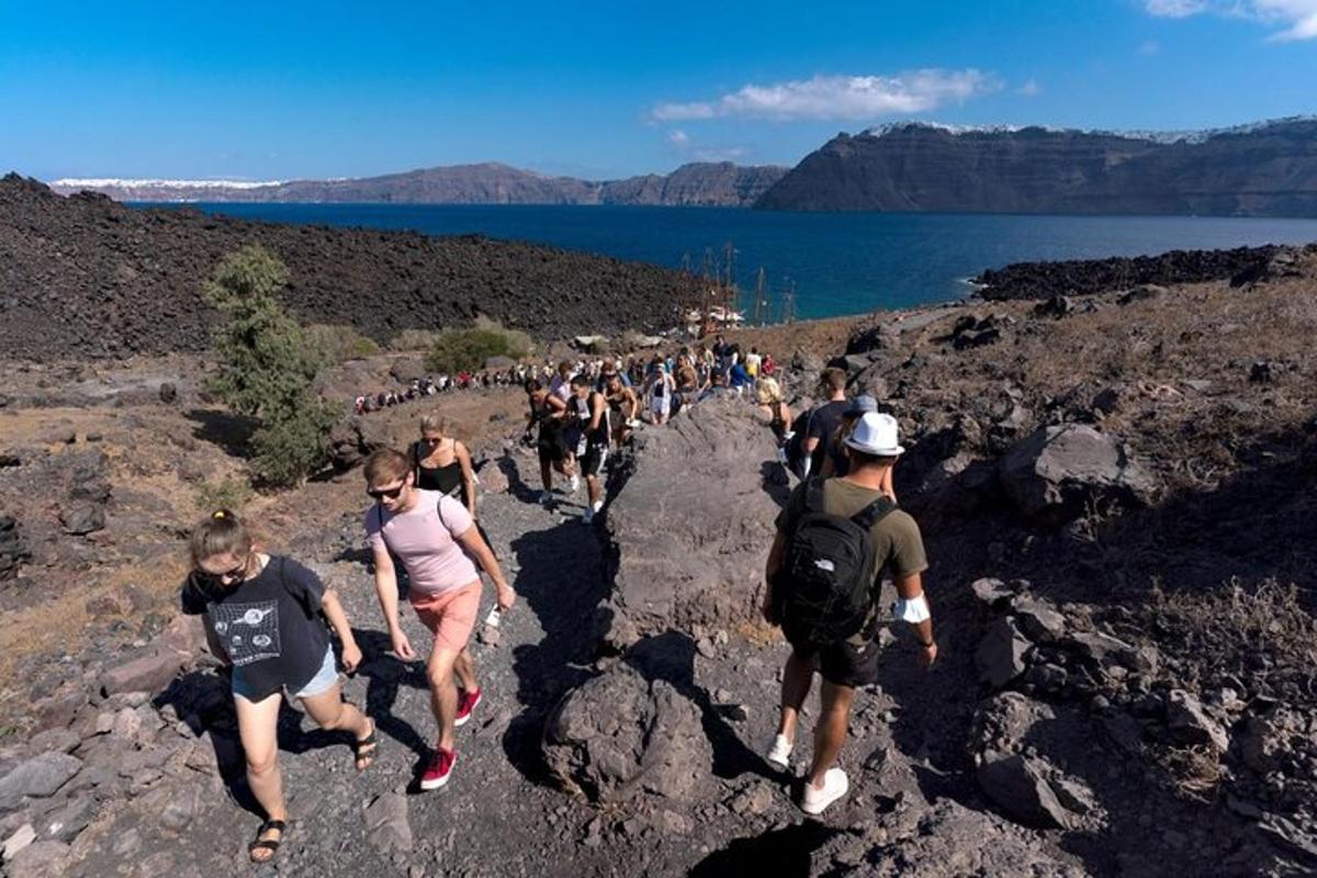 Un gran grupo de personas caminando por un sendero rocoso
