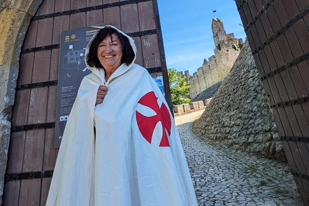 en kvinne i en hvit kappe med et rødt symbol på