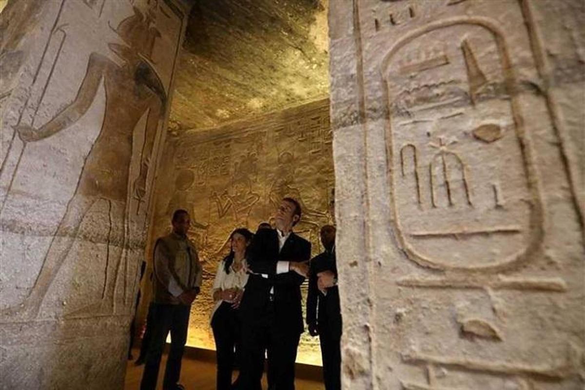 a group of people standing next to a large artifact