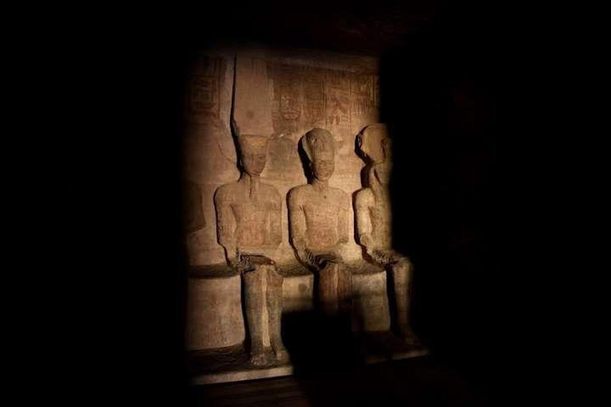 a stone statue of three people on a wall