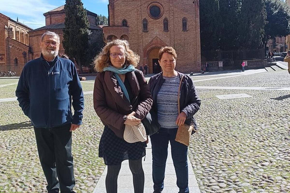 egy három emberből álló csoport áll egy épület előtt