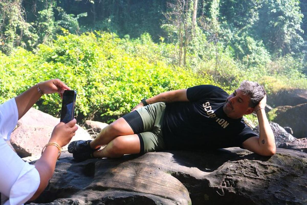 osoba fotografující muže ležícího na skále