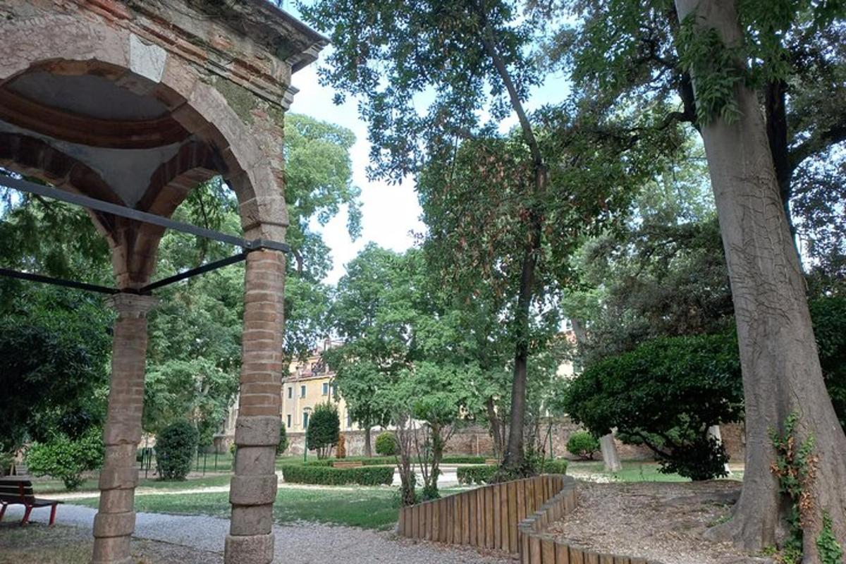 un parco con una recinzione, un albero e un edificio