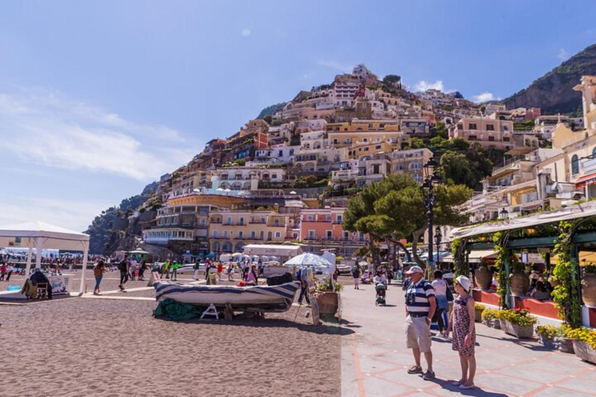 a group of people standing on a beach with a mountain
