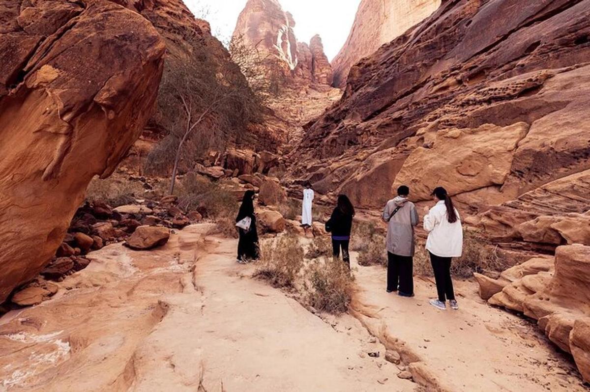a group of people walking through a canyon