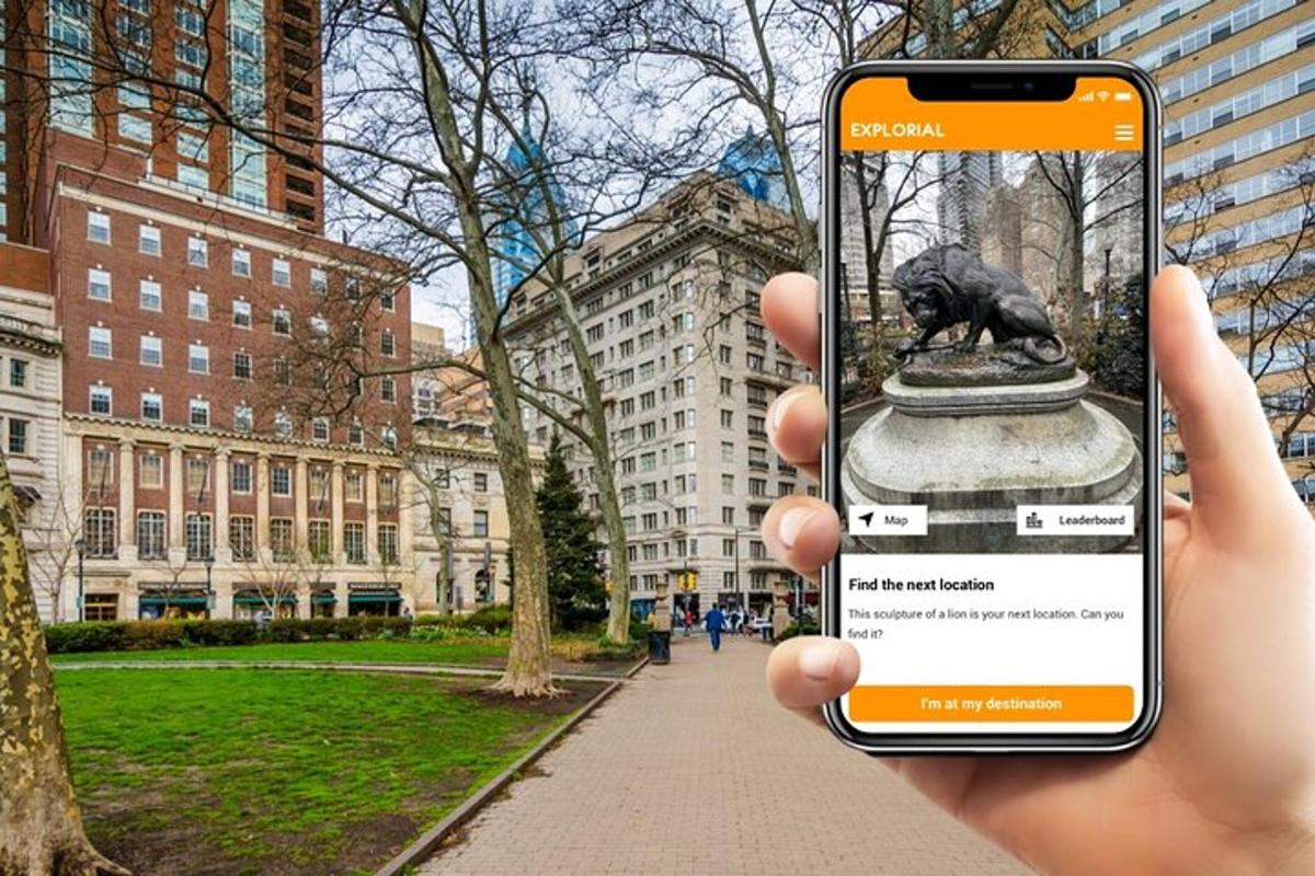 o persoană care ține un telefon mobil în mână pentru a fotografia o statuie
