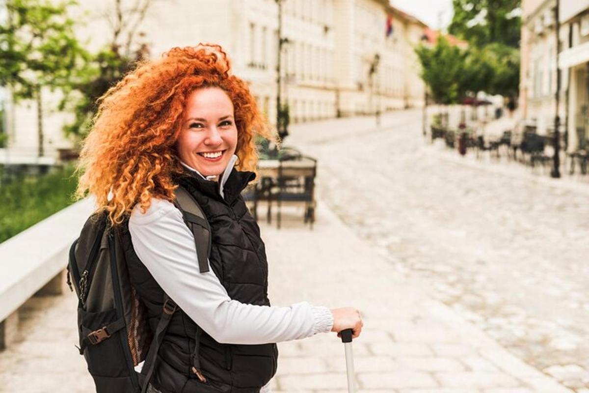 žena s rudými kudrnatými vlasy stojící na ulici