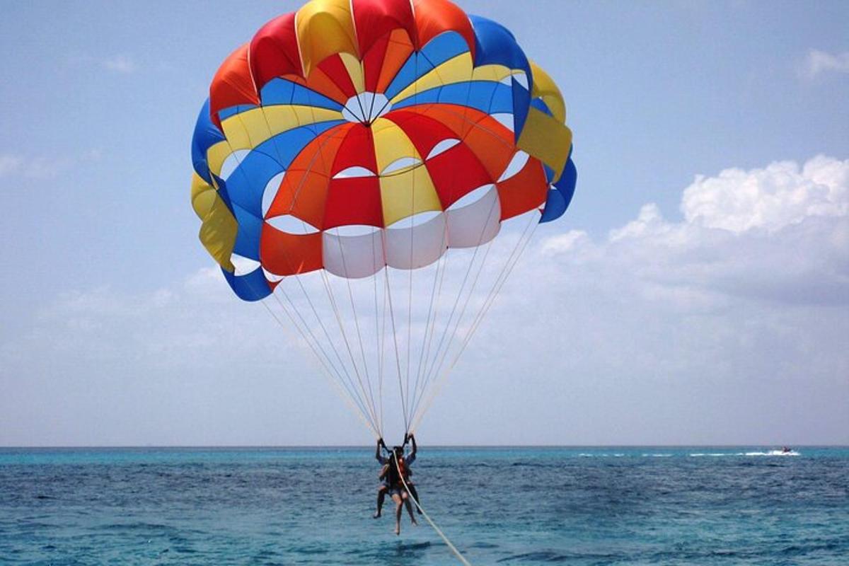 a person flying a parachute over the ocean
