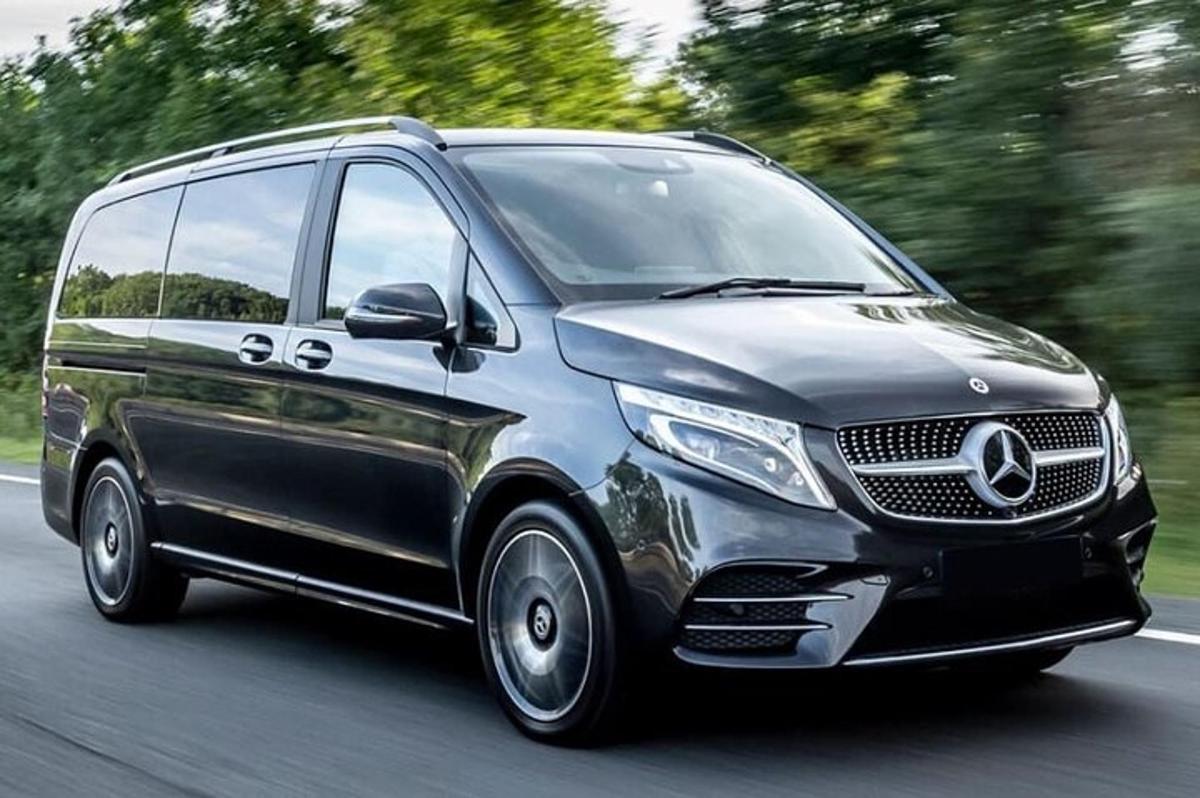 a mercedes benz van driving down a road