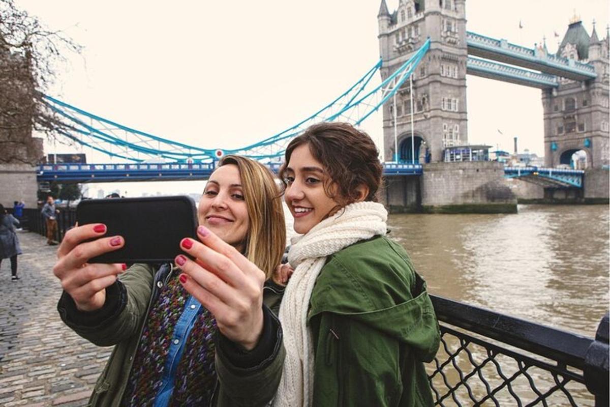 two women taking a picture of the tower bridge