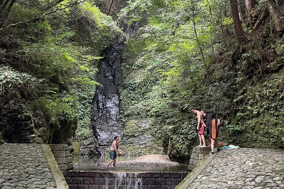 sekumpulan orang berdiri di atas air terjun