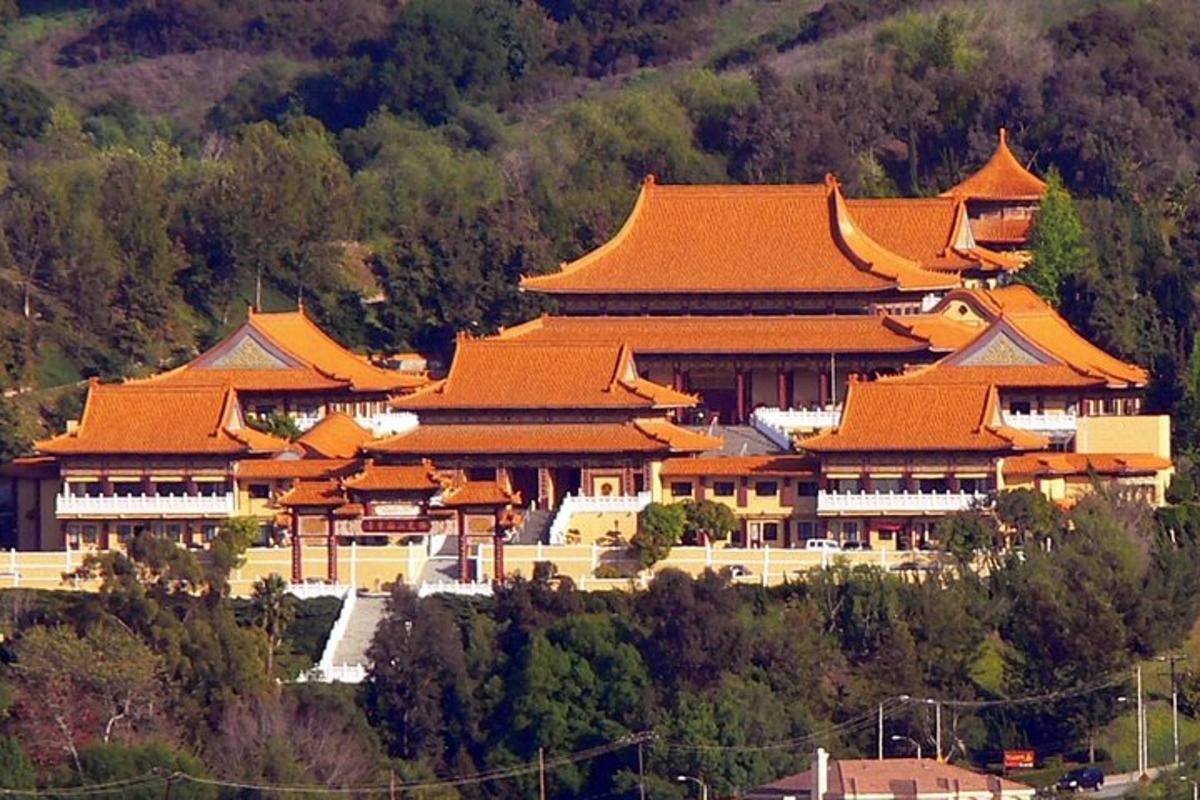 Un gran edificio con techos naranjas en una montaña.