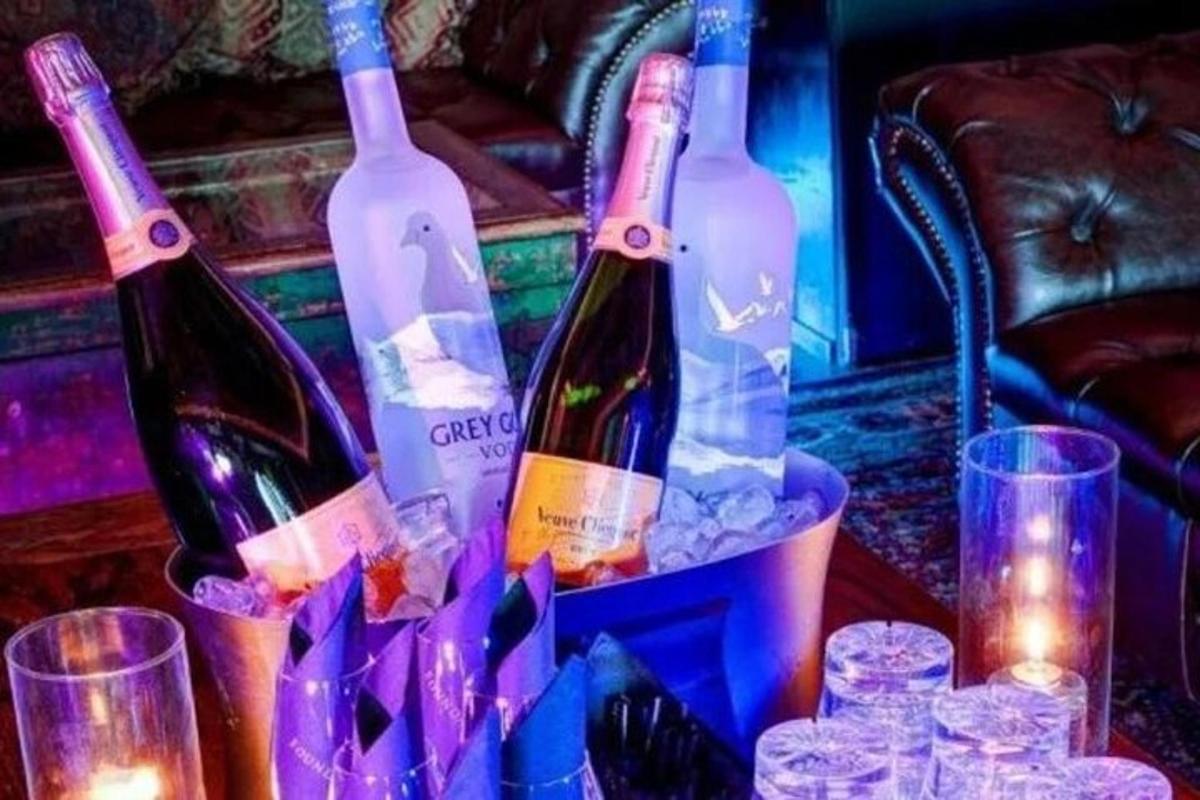 tre bottiglie di vino in un secchio su un tavolo