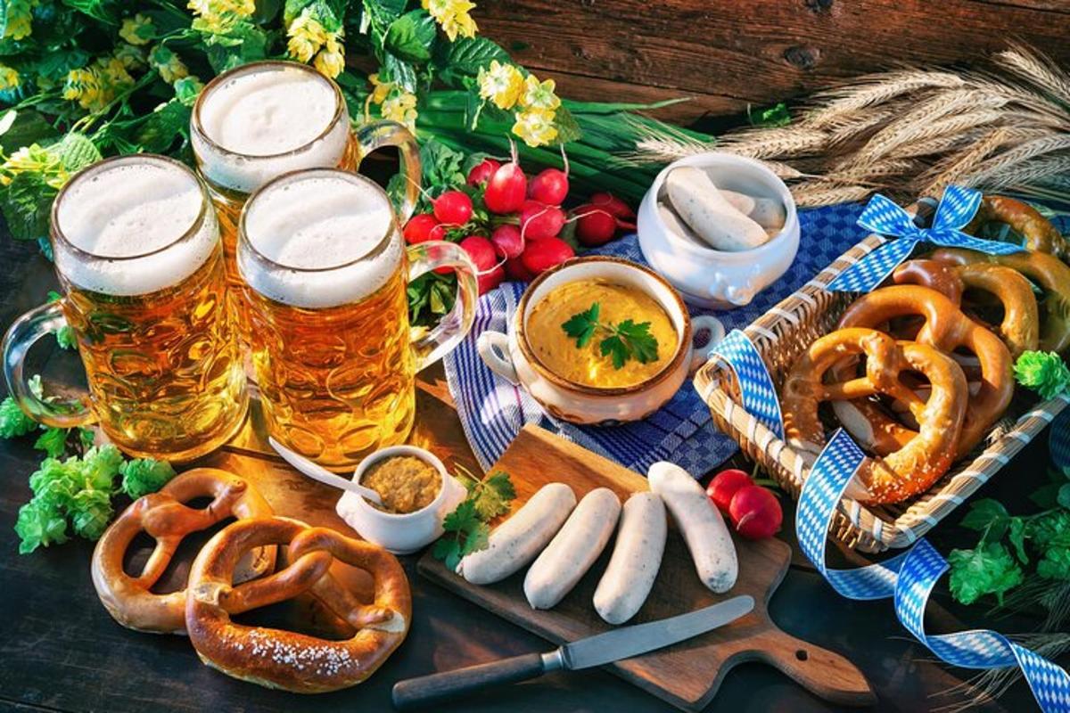stůl se dvěma sklenicemi piva, preclíky a cibulovými kroužky