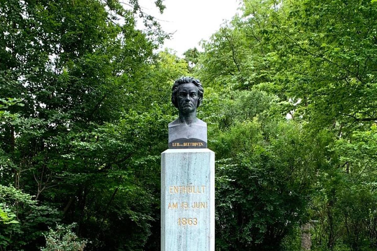 una statua di un busto di un uomo davanti agli alberi