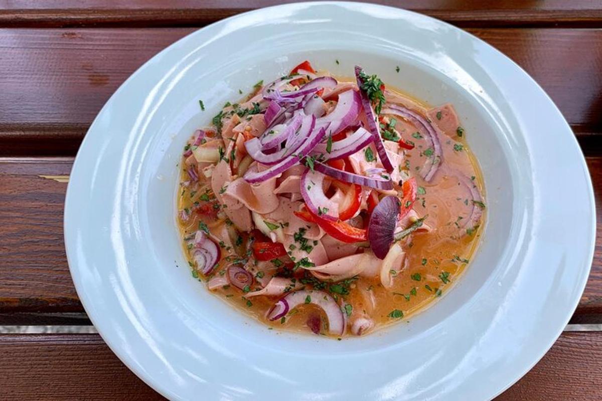 un piatto bianco con una ciotola di zuppa con cipolle