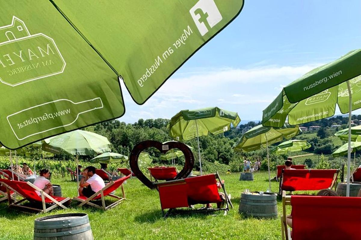 un gruppo di persone sedute su sedie da giardino sotto ombrelloni verdi