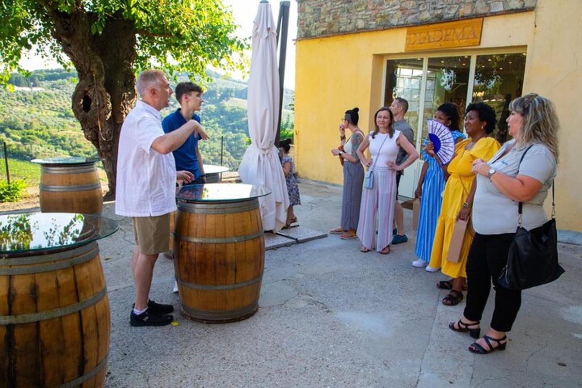 un gruppo di persone in piedi fuori da un edificio con dei barili