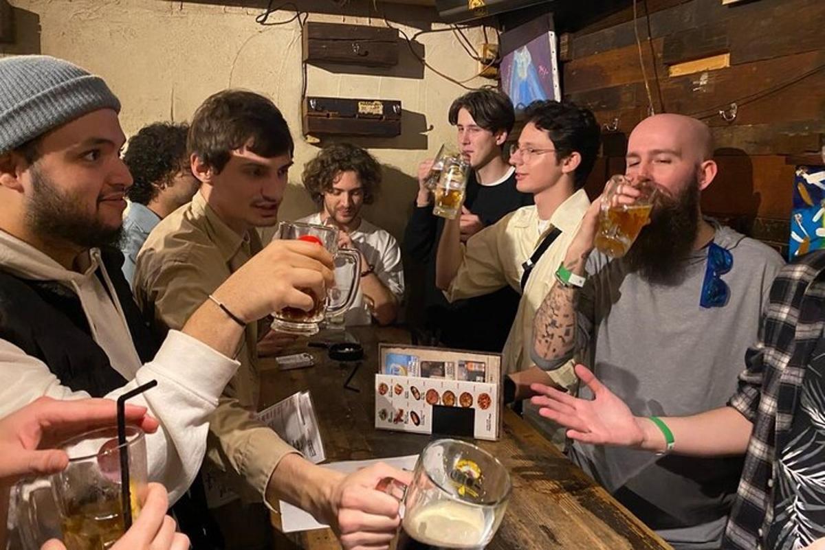 skupina mužů pijících pivo v baru