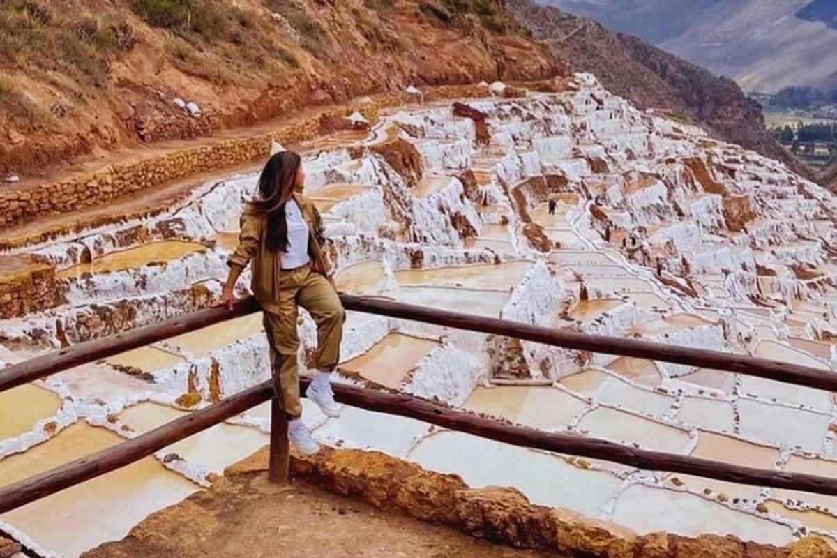 жена стоји на огради и гледа у планину