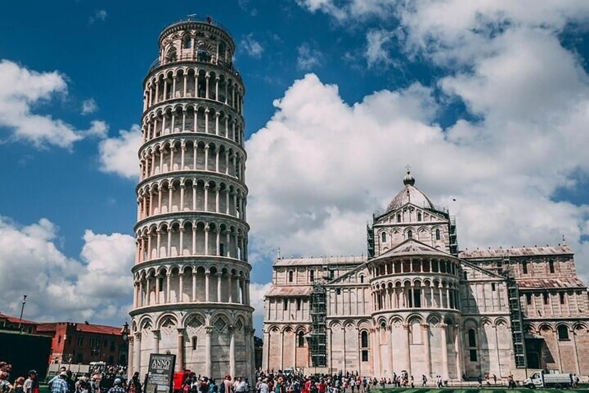 un gruppo di persone in piedi accanto alla torre pendente