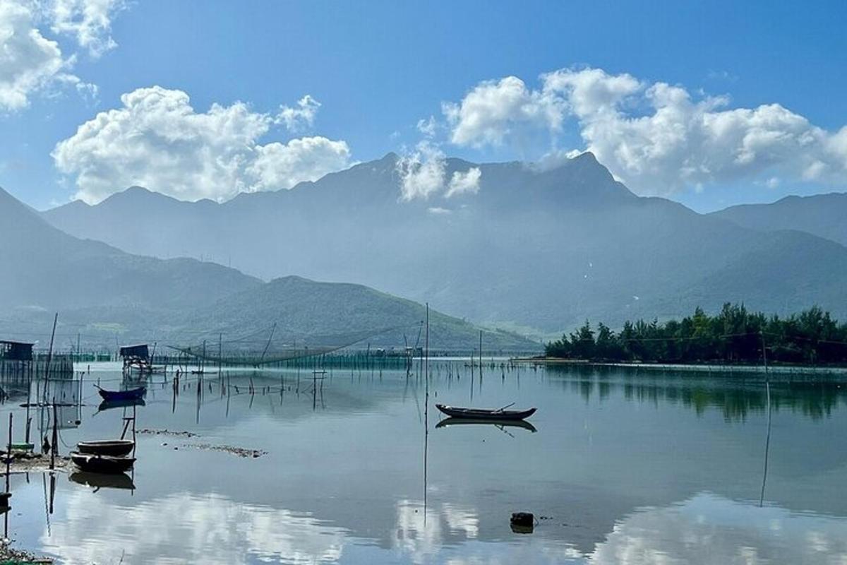 hai chiếc thuyền trên hồ với những ngọn núi ở phía sau