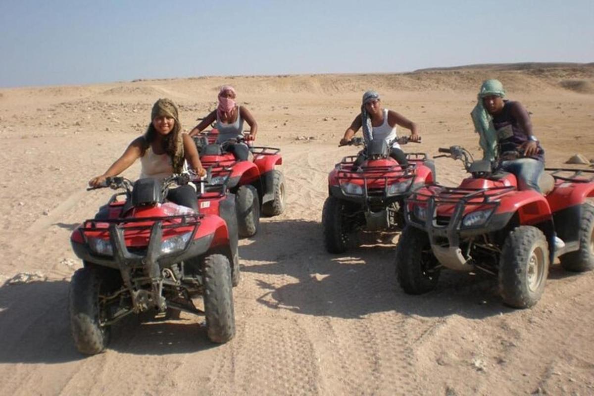 sekelompok orang mengendarai ATV di padang pasir
