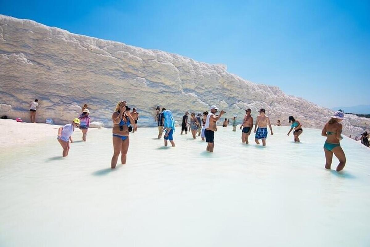 een groep mensen die door het water op een strand loopt