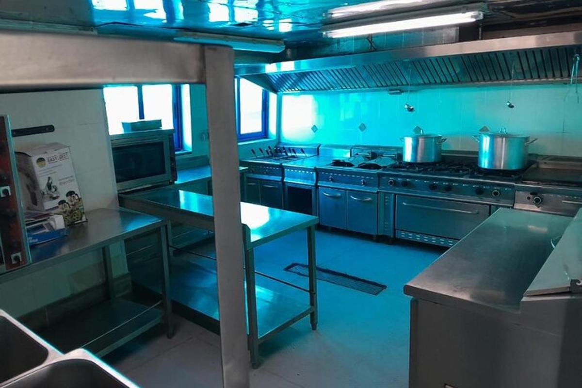 uma grande cozinha com tetos azuis e eletrodomésticos de aço
