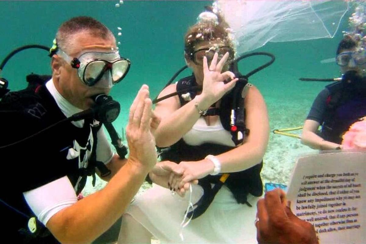 a man and a woman in the water holding hands