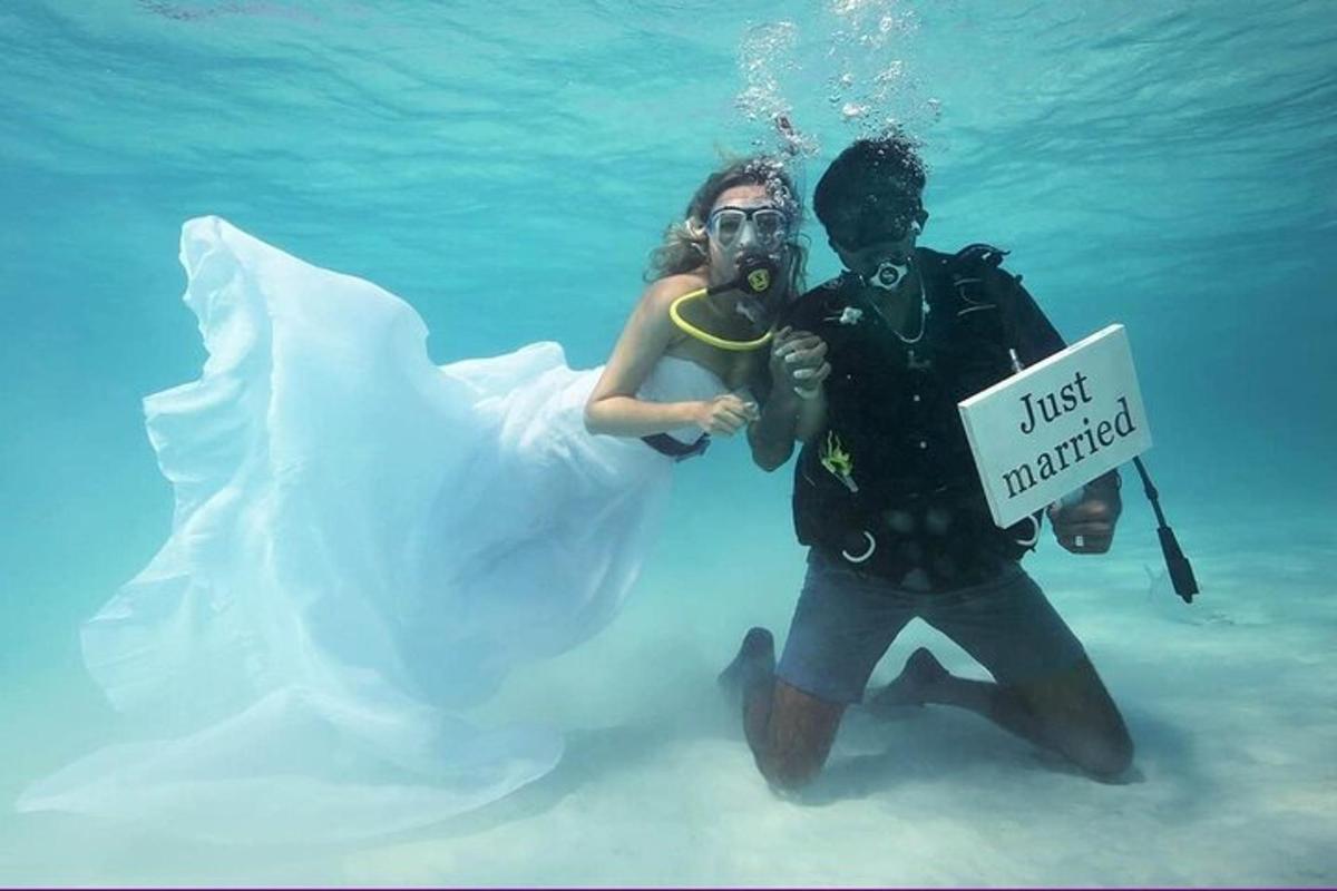 a underwater picture of a bride and groom in the water