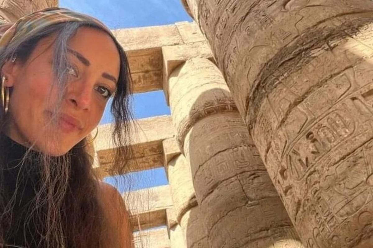una donna è in piedi accanto a un pilastro di pietra
