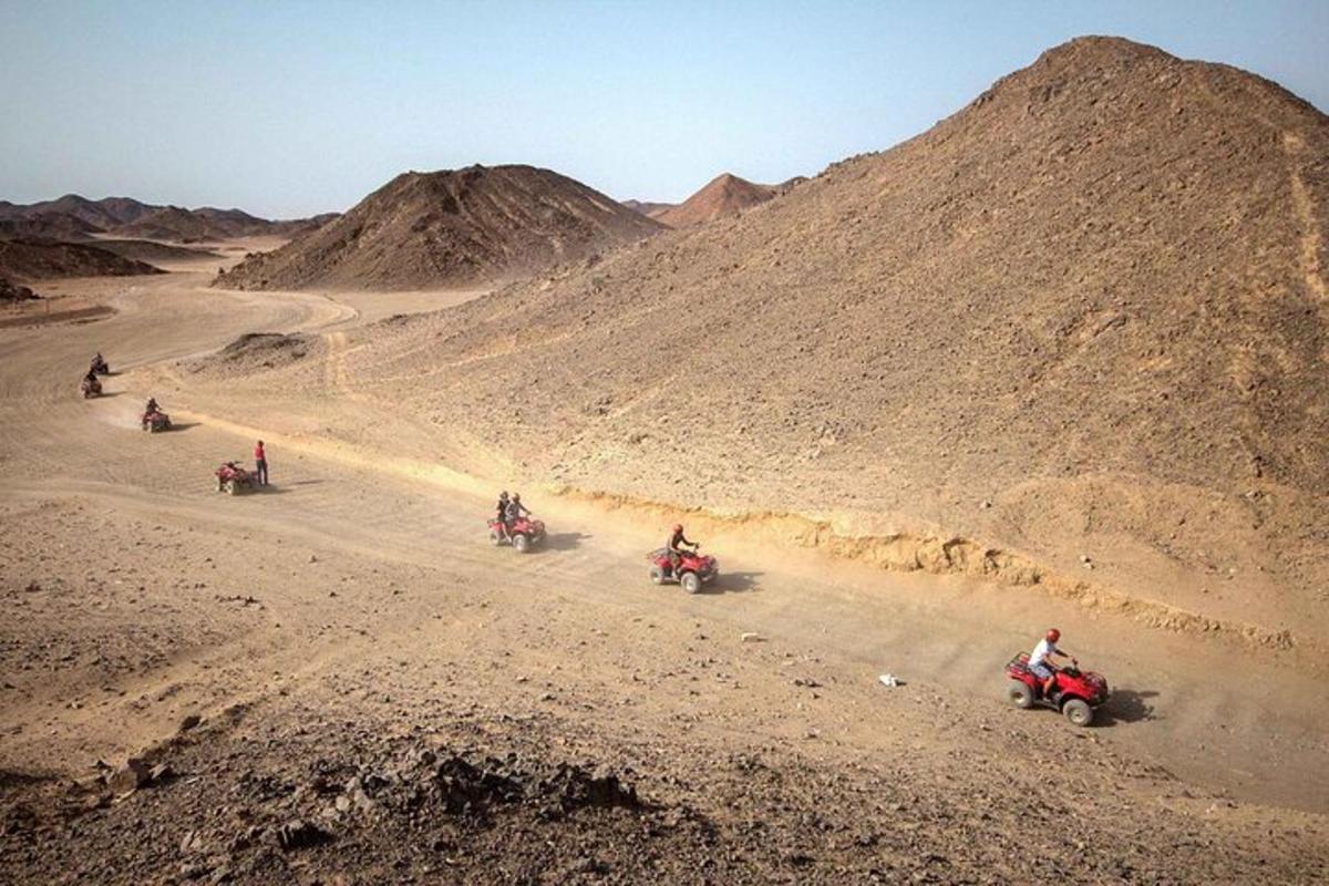 eine Gruppe von Menschen, die auf einem Feldweg mit Motorrädern unterwegs sind