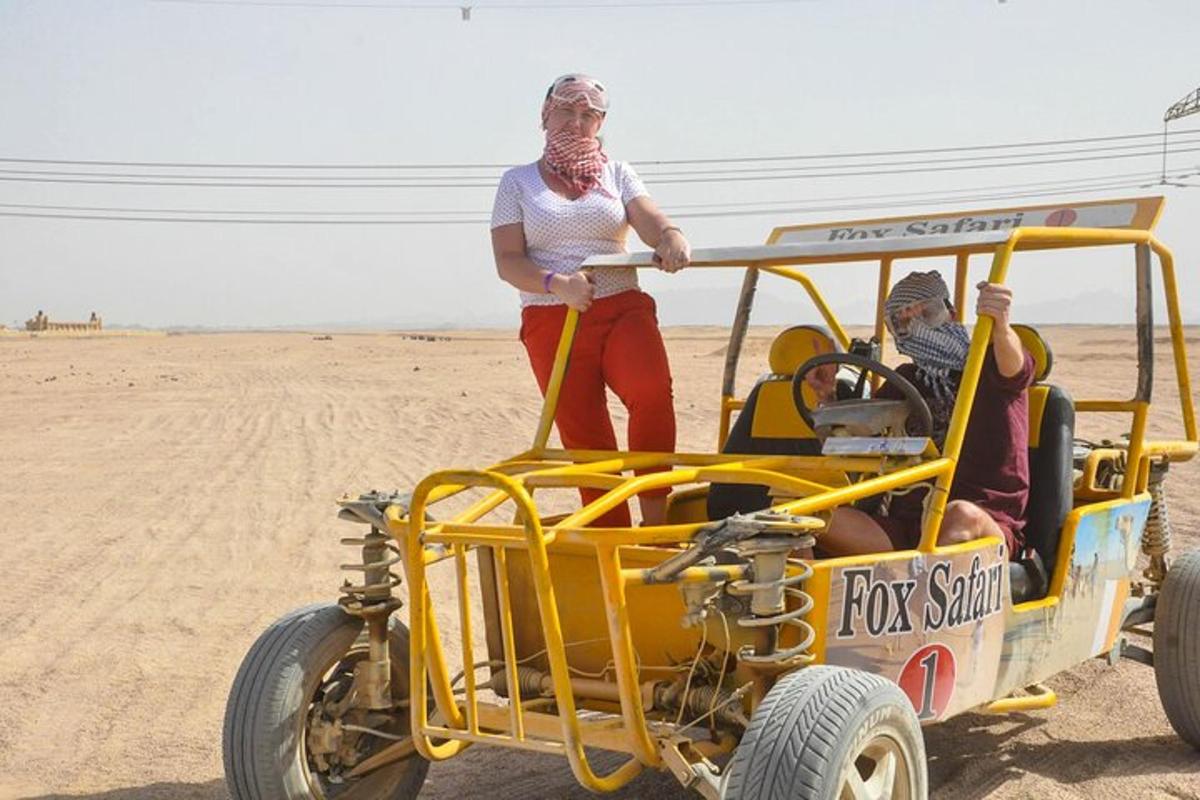 una dona dreta a la part posterior d'un cotxe groc al desert