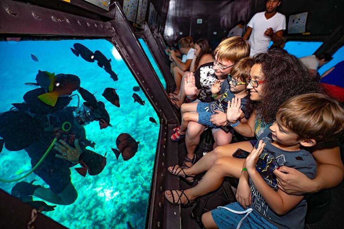 een groep mensen die vissen in een aquarium bekijkt