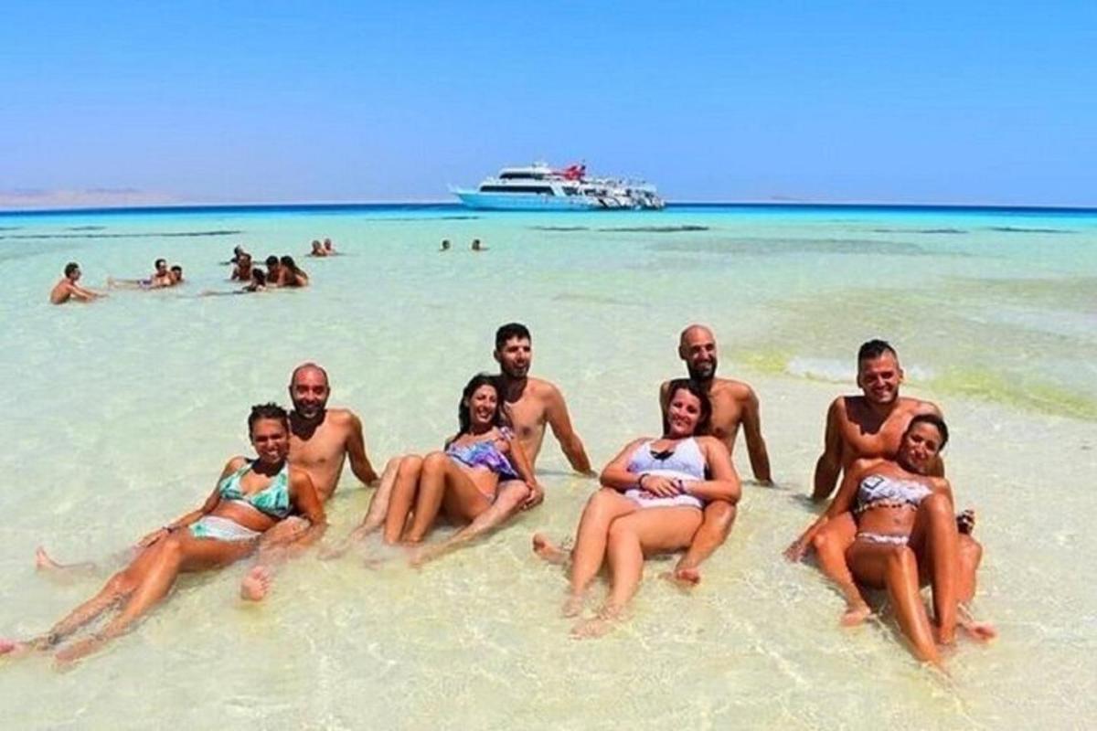 un grup de oameni care stau în nisipul de pe o plajă