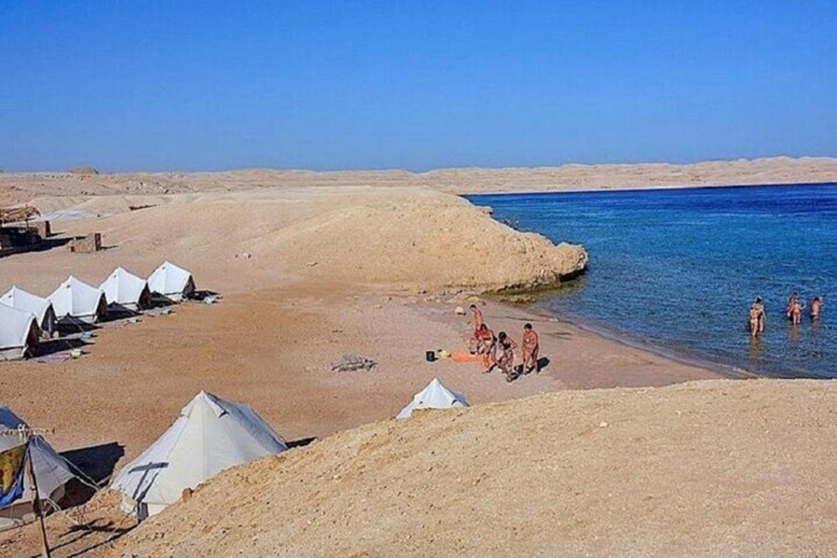 un gruppo di persone su una spiaggia con le tende